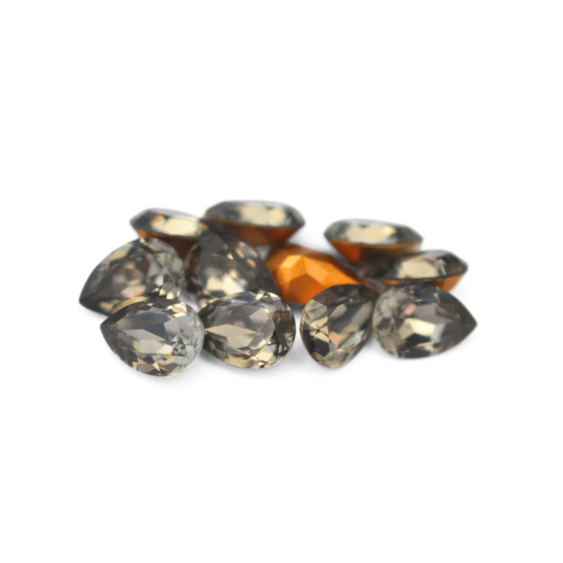 Pear shaped faceted Austrian crystal rhinestones in the color Black Diamond displayed on a white background.