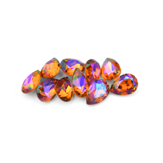 Pear shaped faceted Austrian crystal rhinestones in the color Topaz Glacier Blue displayed on a white background.