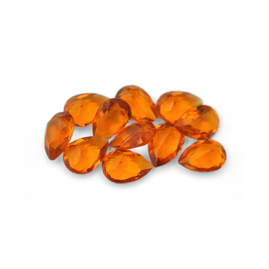 Pear shaped faceted Austrian crystal rhinestones in the color Topaz Unfoiled displayed on a white background.