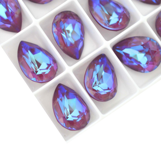 Pear shape faceted Austrian crystal rhinestones in the color Burgundy Delite displayed on a white background.
