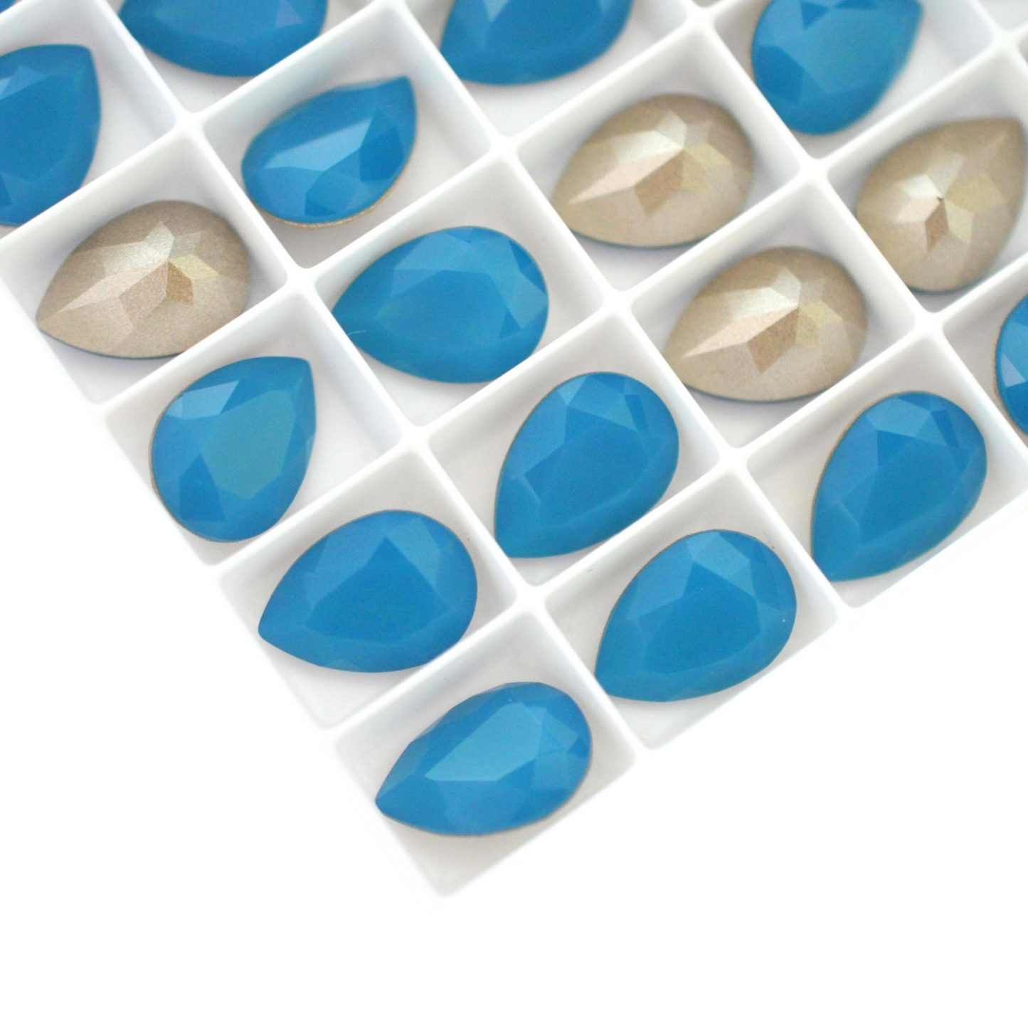 Pear shape faceted Austrian crystal rhinestones in the color Caribbean Blue Opal displayed on a white background.