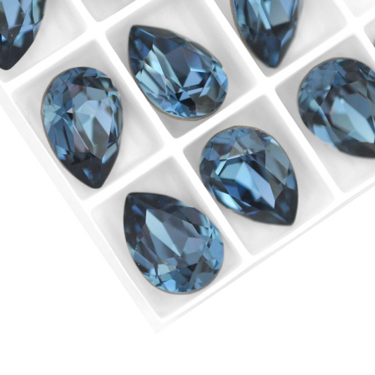 Pear shape faceted Austrian crystal rhinestones in the color Denim Blue displayed on a white background.