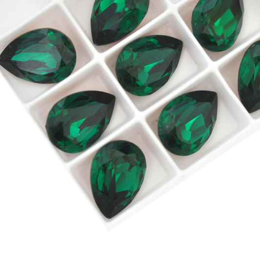Pear shape faceted Austrian crystal rhinestones in the color Emerald displayed on a white background.