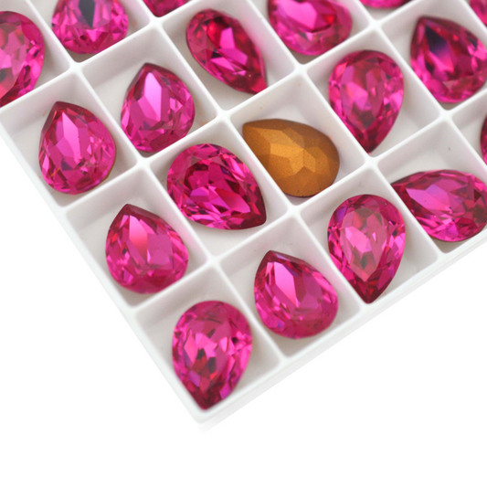 Pear shape faceted Austrian crystal rhinestones in the color Fuchsia displayed on a white background.