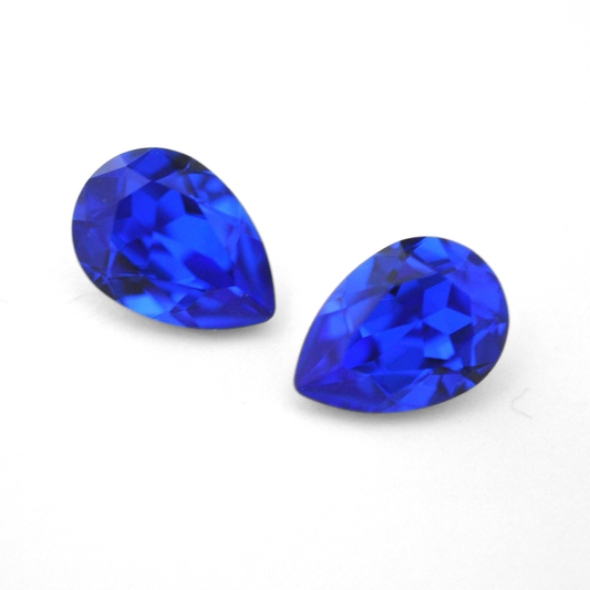 Pear shape faceted Austrian crystal rhinestones in the color Majestic Blue displayed on a white background.