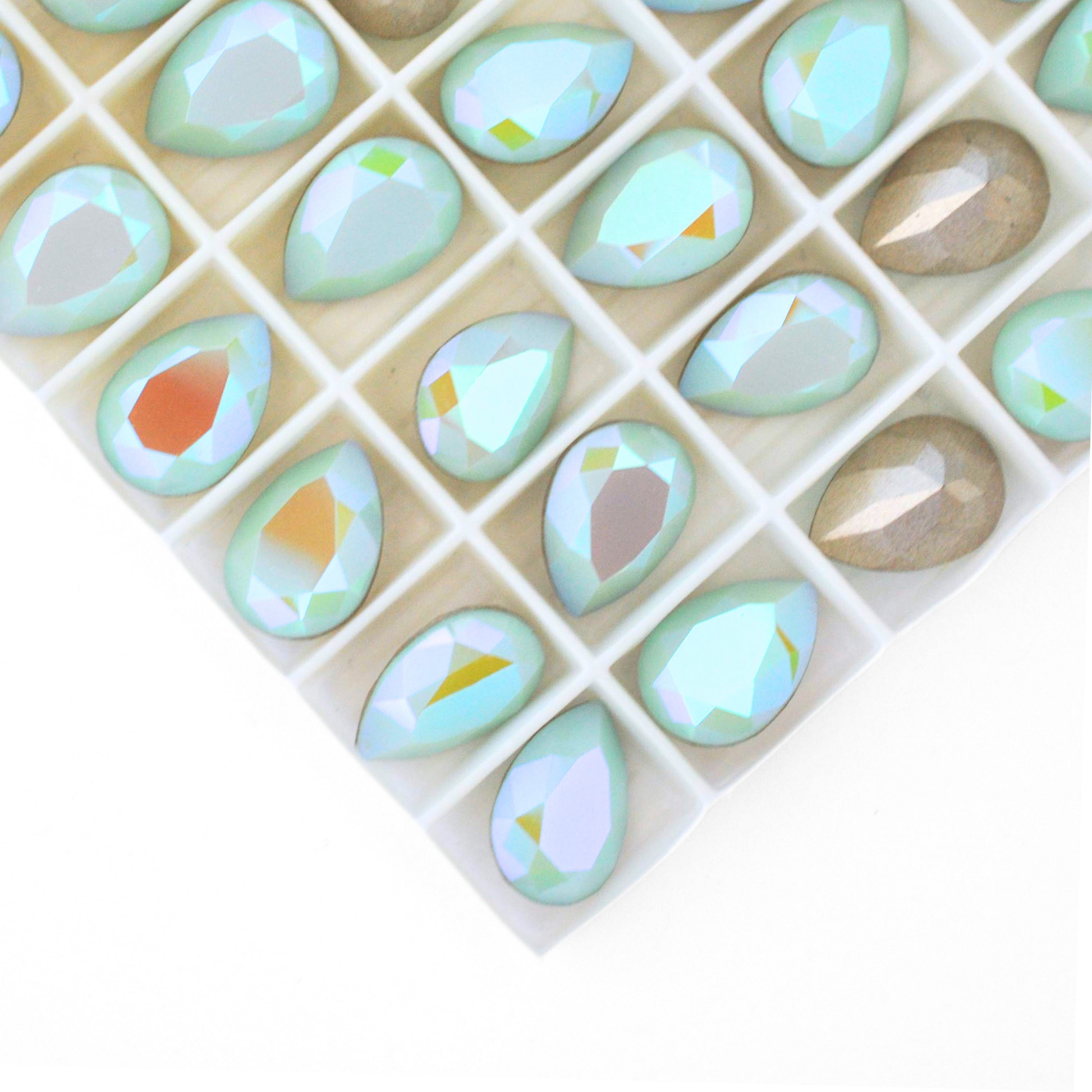 Pear shape faceted Austrian crystal rhinestones in the color Mint Alabaster Glacier Blue displayed on a white background.