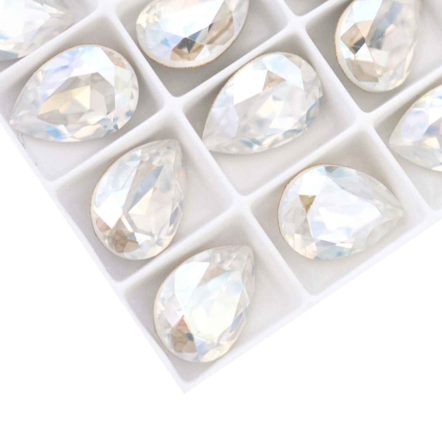 Pear shape faceted Austrian crystal rhinestones in the color Moonlight displayed on a white background.