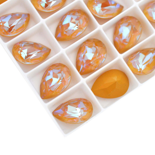 Pear shape faceted Austrian crystal rhinestones in the color Ochre Delite displayed on a white background.