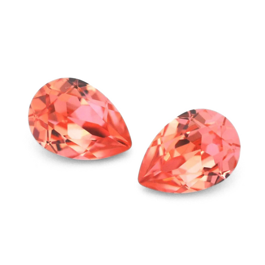 Pear shape faceted Austrian crystal rhinestones in the color Rose Peach displayed on a white background.