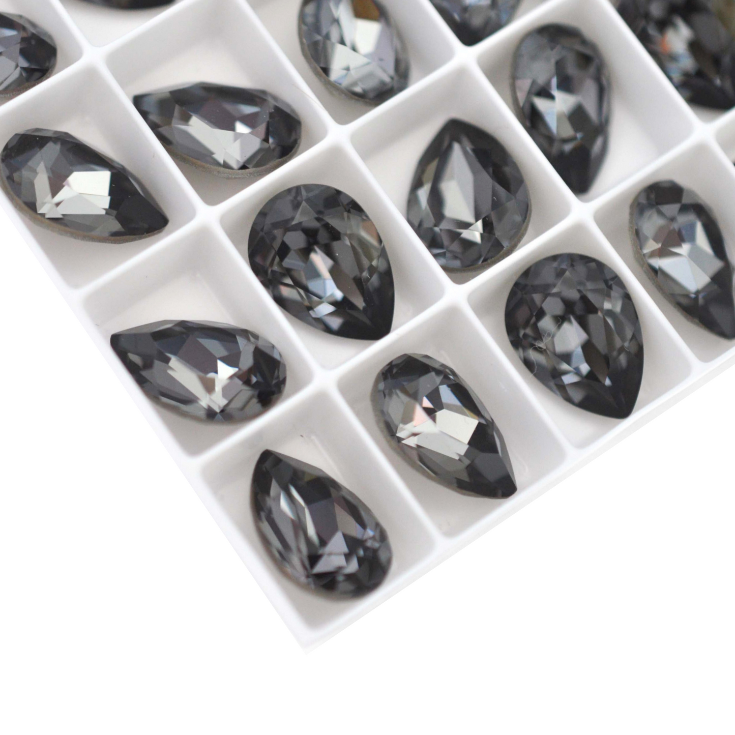 Pear shape faceted Austrian crystal rhinestones in the color Silver Night displayed on a white background.