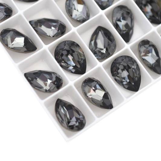 Pear shape faceted Austrian crystal rhinestones in the color Silver Night displayed on a white background.