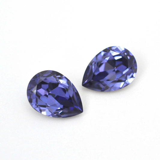 Pear shape faceted Austrian crystal rhinestones in the color Tanzanite displayed on a white background.