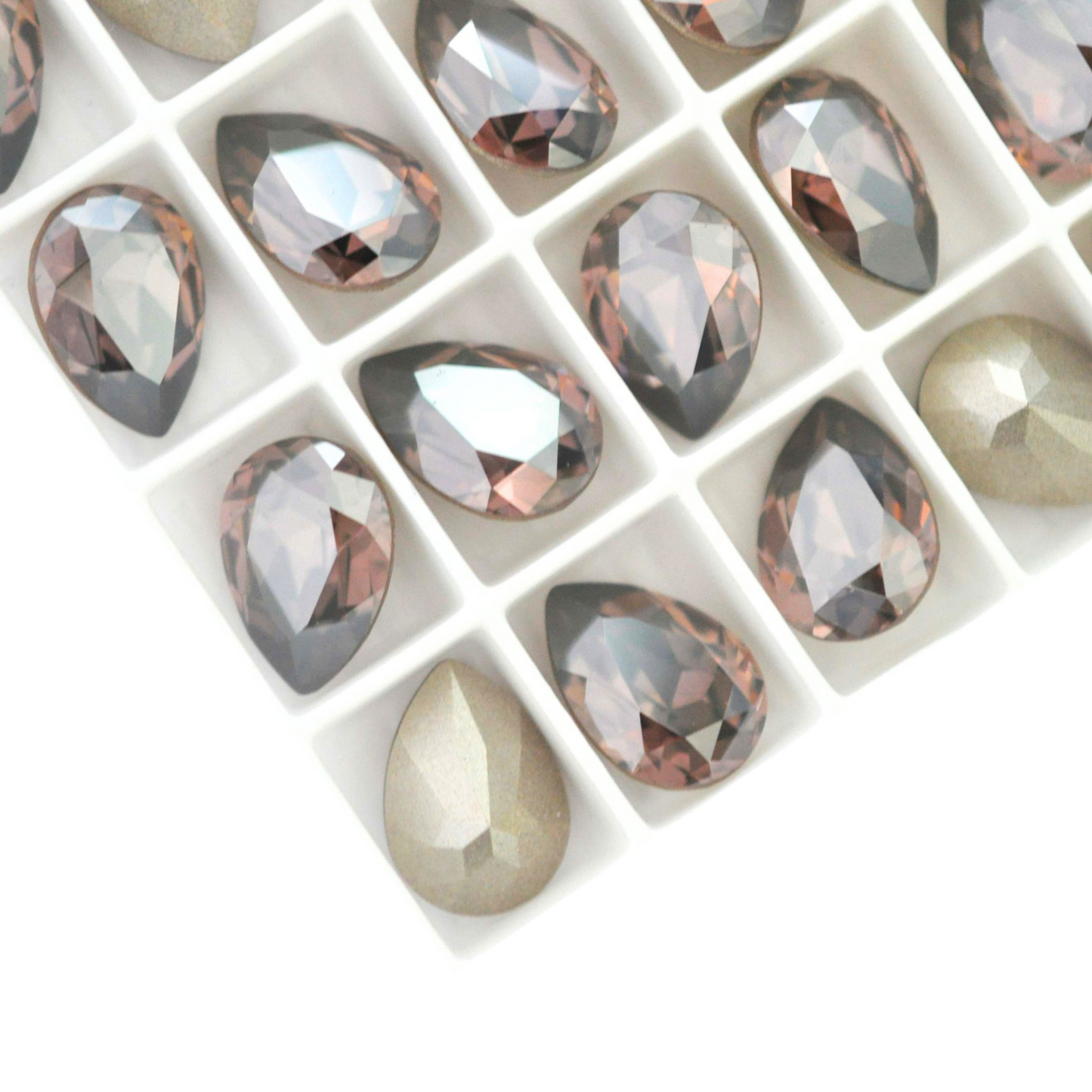 Pear shape faceted Austrian crystal rhinestones in the color Vintage Rose Satin displayed on a white background.