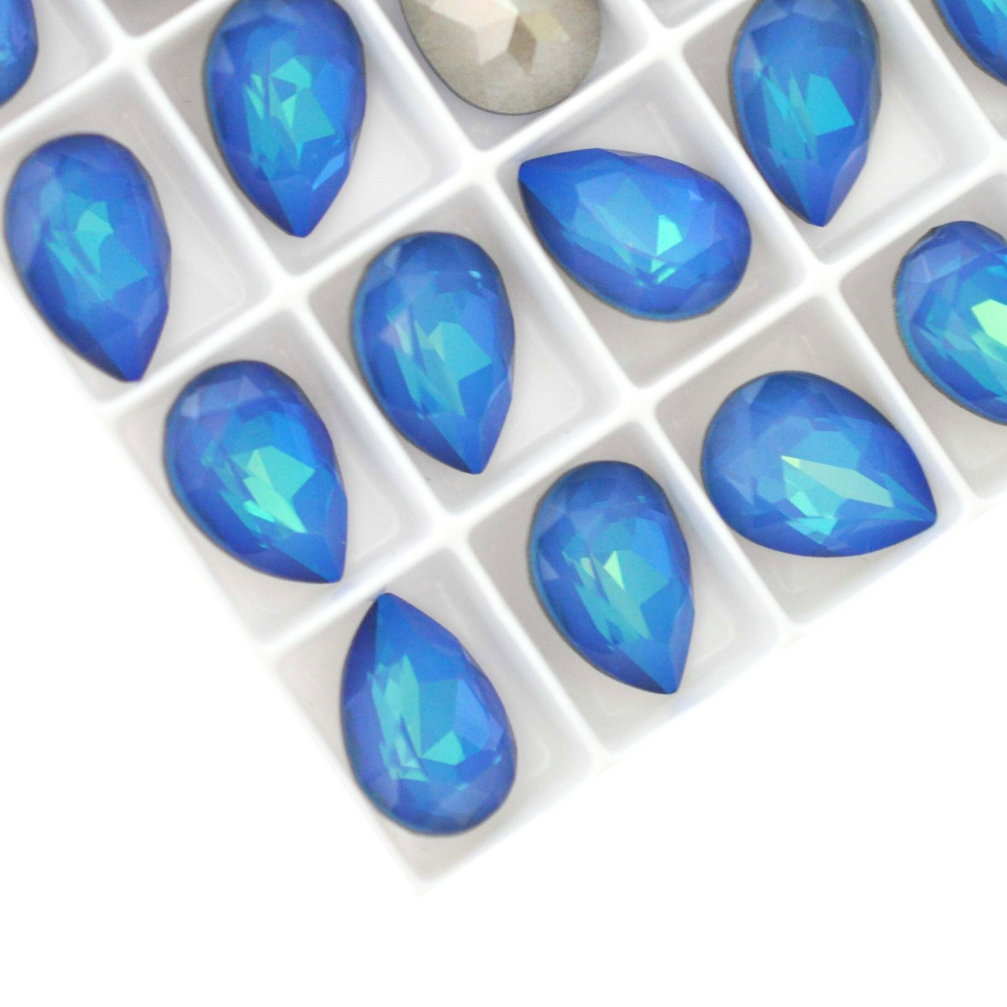 Pear shape faceted Austrian crystal rhinestones in the color White Opal Bermuda Blue displayed on a white background.