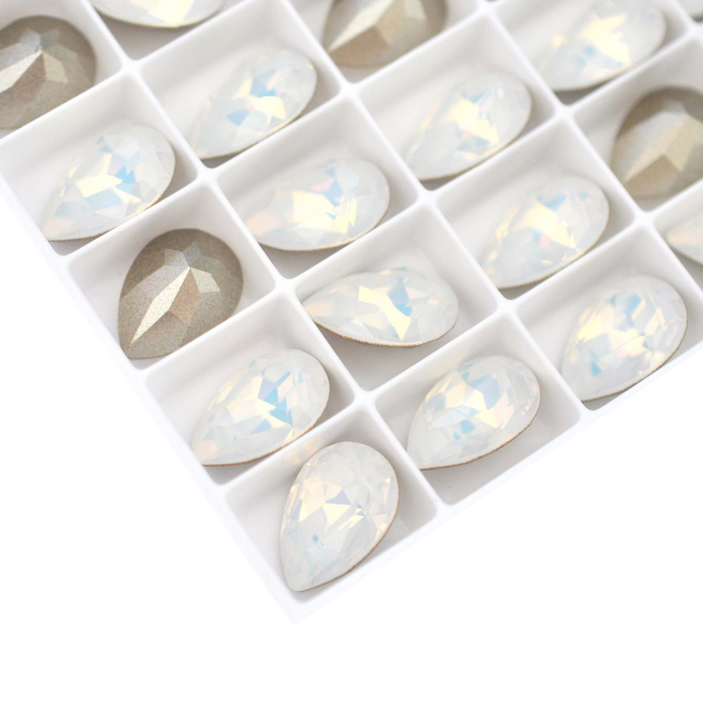 Pear shape faceted Austrian crystal rhinestones in the color White Opal displayed on a white background.
