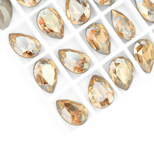Pear shape faceted Austrian crystal rhinestones in the color Golden Shadow displayed on a white background.