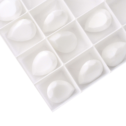 Pear shape faceted Austrian crystal rhinestones in the color Chalk White displayed on a white background.