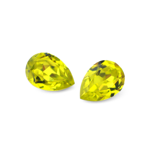 Pear shape faceted Austrian crystal rhinestones in the color Citrus Green displayed on a white background.
