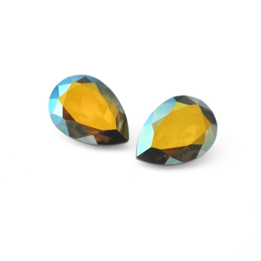 Pear shape faceted Austrian crystal rhinestones in the color Iridescent Green displayed on a white background.