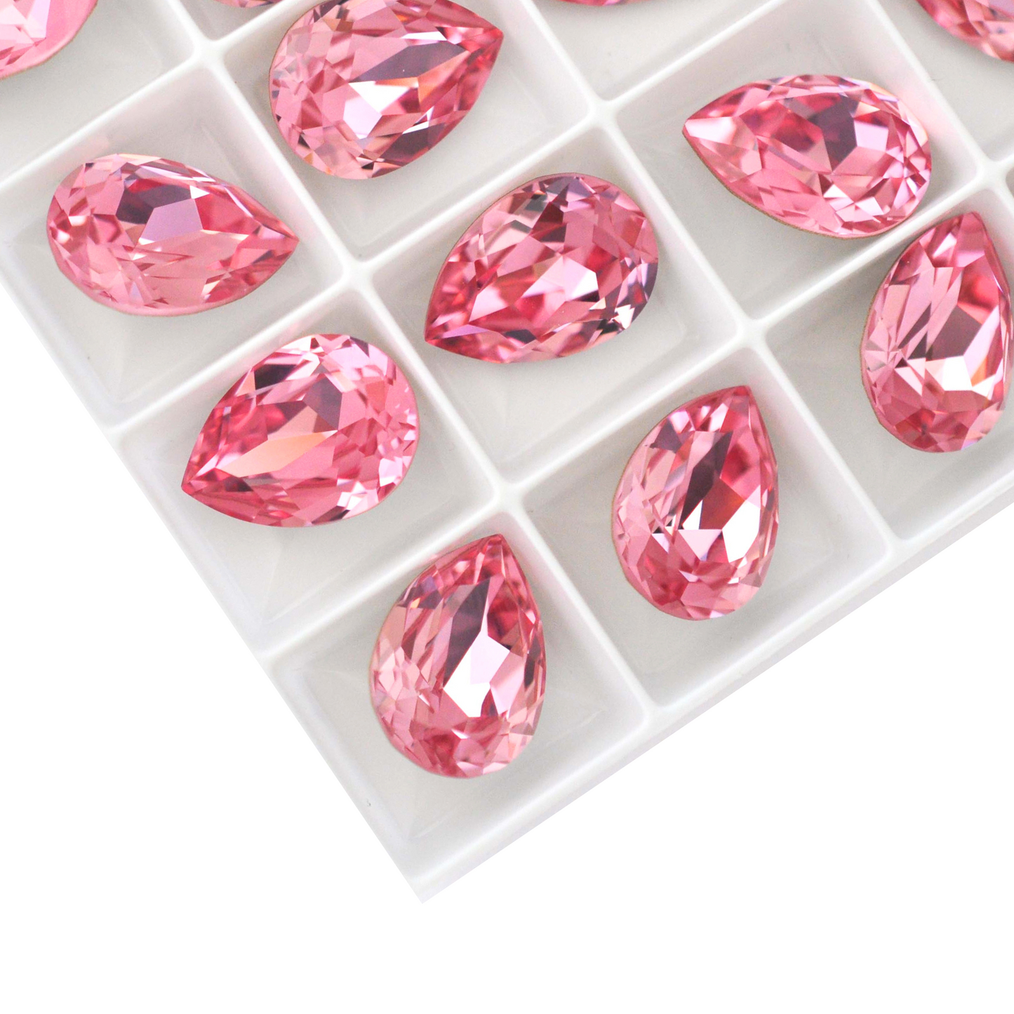 Pear shape faceted Austrian crystal rhinestones in the color Light Rose displayed on a white background.