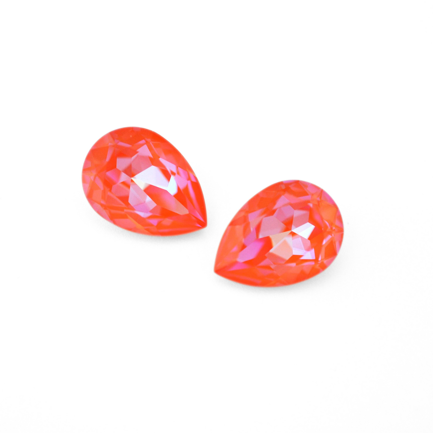 Pear shape faceted Austrian crystal rhinestones in the color Orange Glow Delite displayed on a white background.