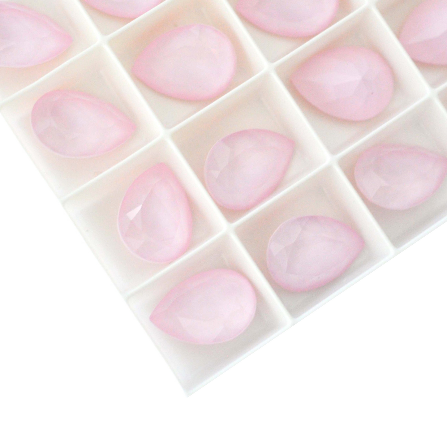 Pear shape faceted Austrian crystal rhinestones in the color Powder Rose displayed on a white background.
