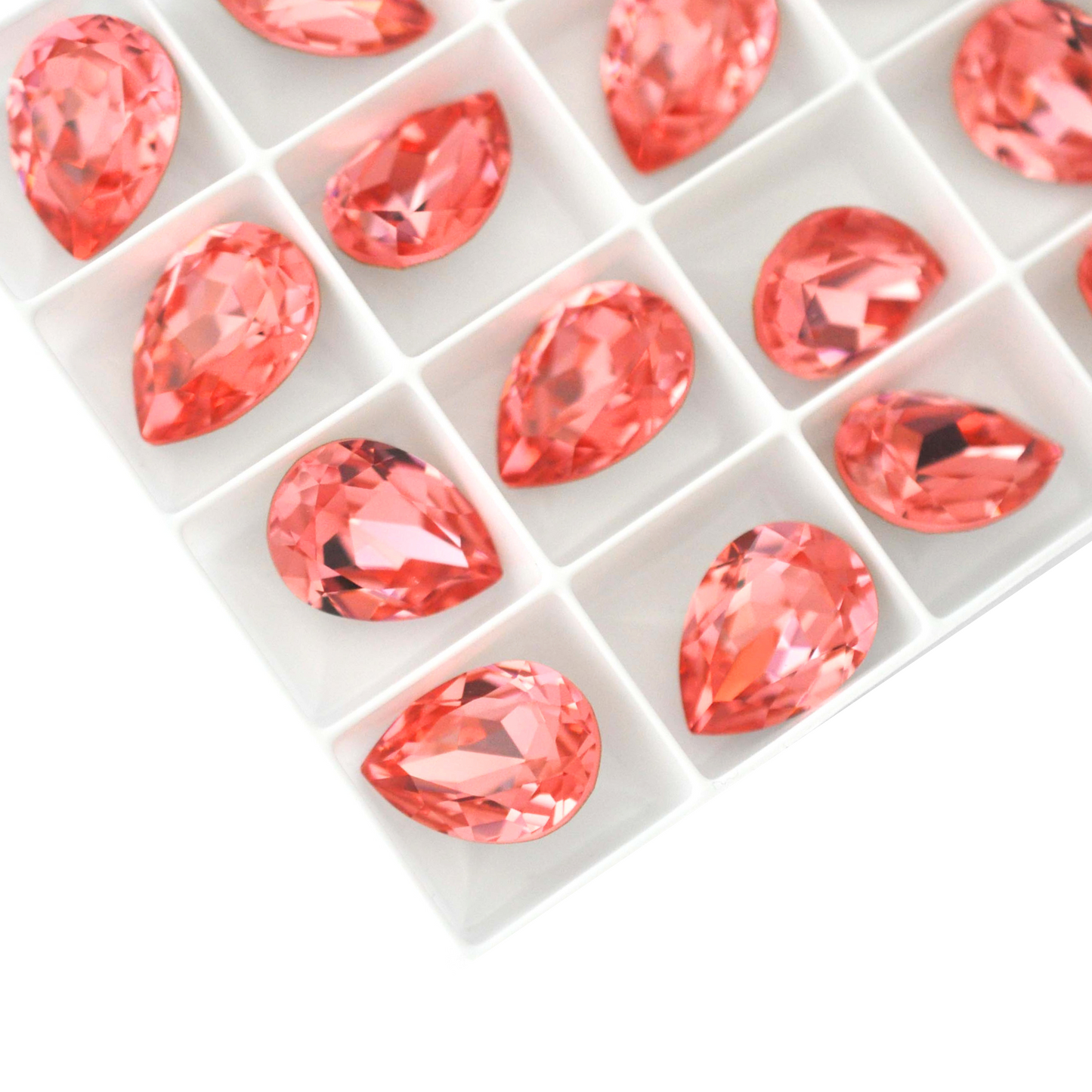 Pear shape faceted Austrian crystal rhinestones in the color Rose Peach displayed on a white background.
