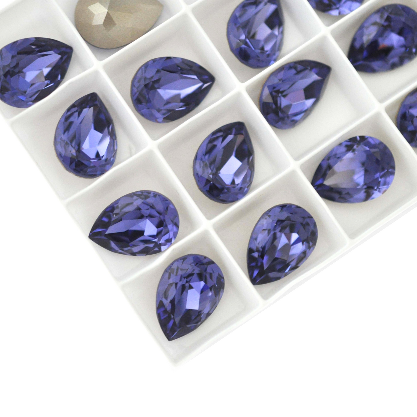 Pear shape faceted Austrian crystal rhinestones in the color Tanzanite displayed on a white background.