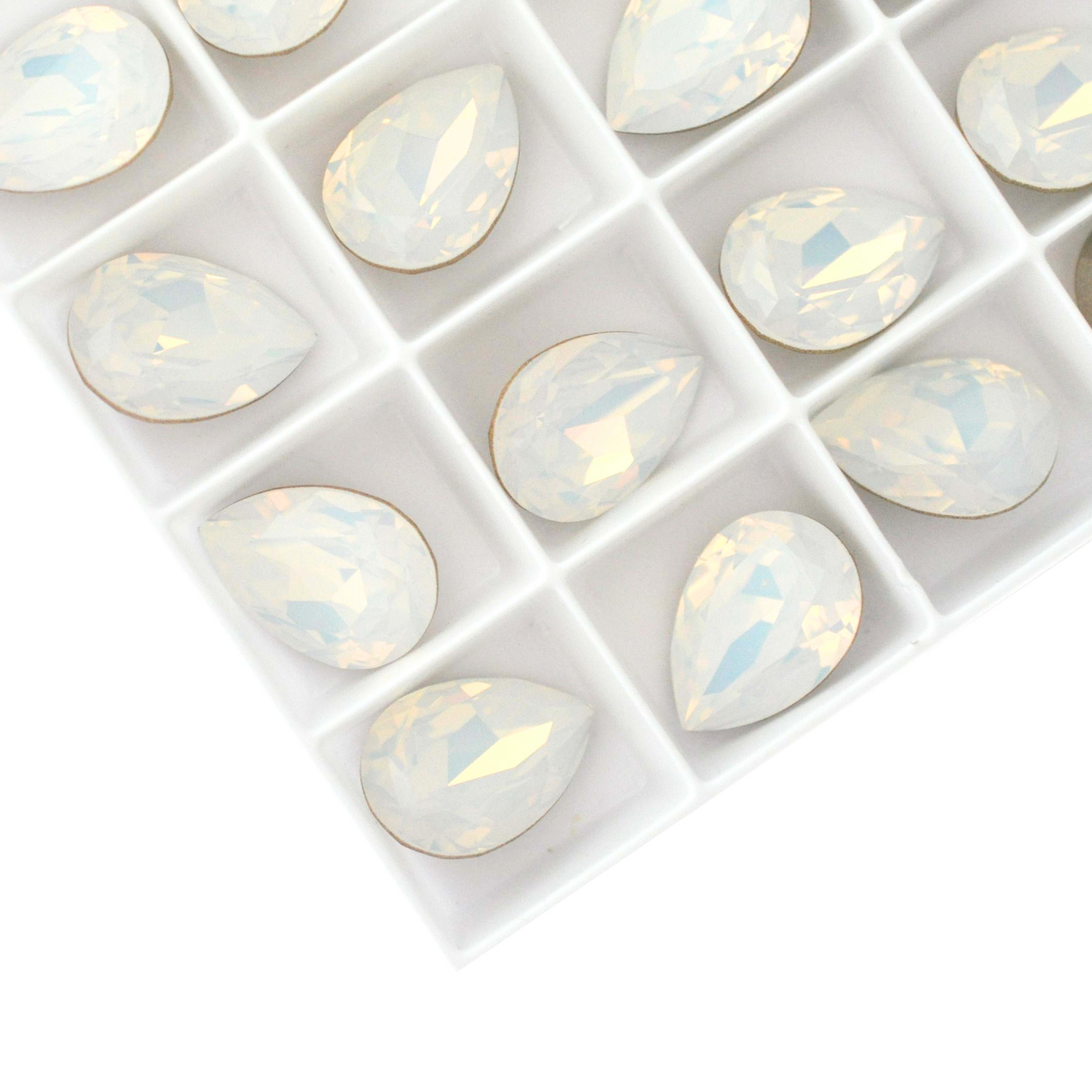 Pear shape faceted Austrian crystal rhinestones in the color White Opal displayed on a white background.