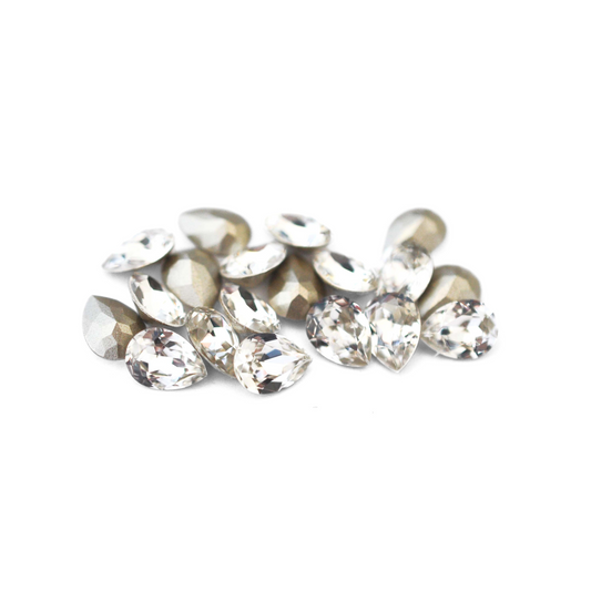 Pear shaped faceted Austrian crystal rhinestones in the color Crystal displayed on a white background.
