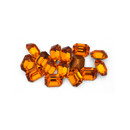 Octagon shaped faceted Austrian crystal rhinestones in the color Topaz displayed on a white background.