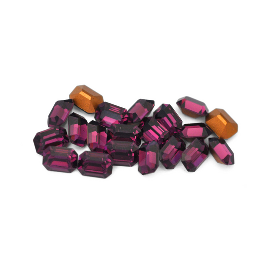 Octagon shaped faceted Austrian crystal rhinestones in the color Amethyst displayed on a white background.