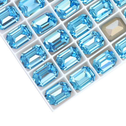 Octagon shaped faceted Austrian crystal rhinestones in the color Aquamarine displayed on a white background.