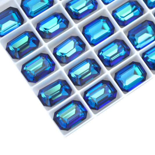 Octagon shaped faceted Austrian crystal rhinestones in the color Bermuda Blue displayed on a white background.