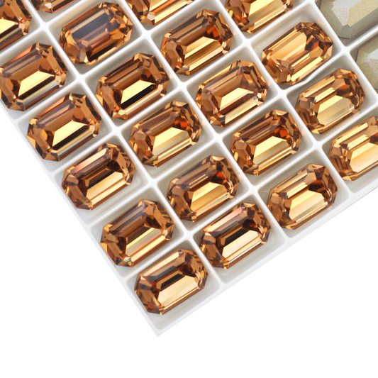 Octagon shaped faceted Austrian crystal rhinestones in the color Light Colorado Topaz displayed on a white background.