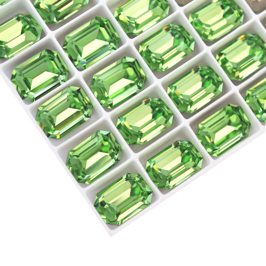 Octagon shaped faceted Austrian crystal rhinestones in the color Peridot displayed on a white background.
