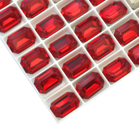 Octagon shaped faceted Austrian crystal rhinestones in the color Siam displayed on a white background.