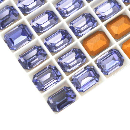 Octagon shaped faceted Austrian crystal rhinestones in the color Tanzanite displayed on a white background.