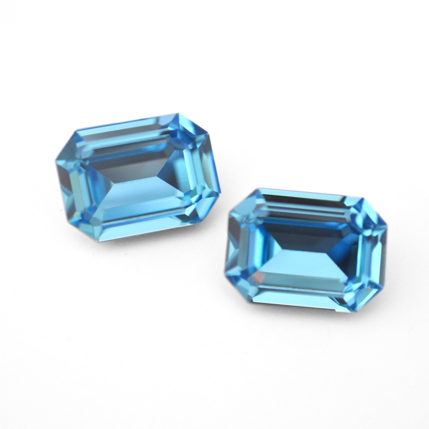 Octagon shaped faceted Austrian crystal rhinestones in the color Aquamarine displayed on a white background.