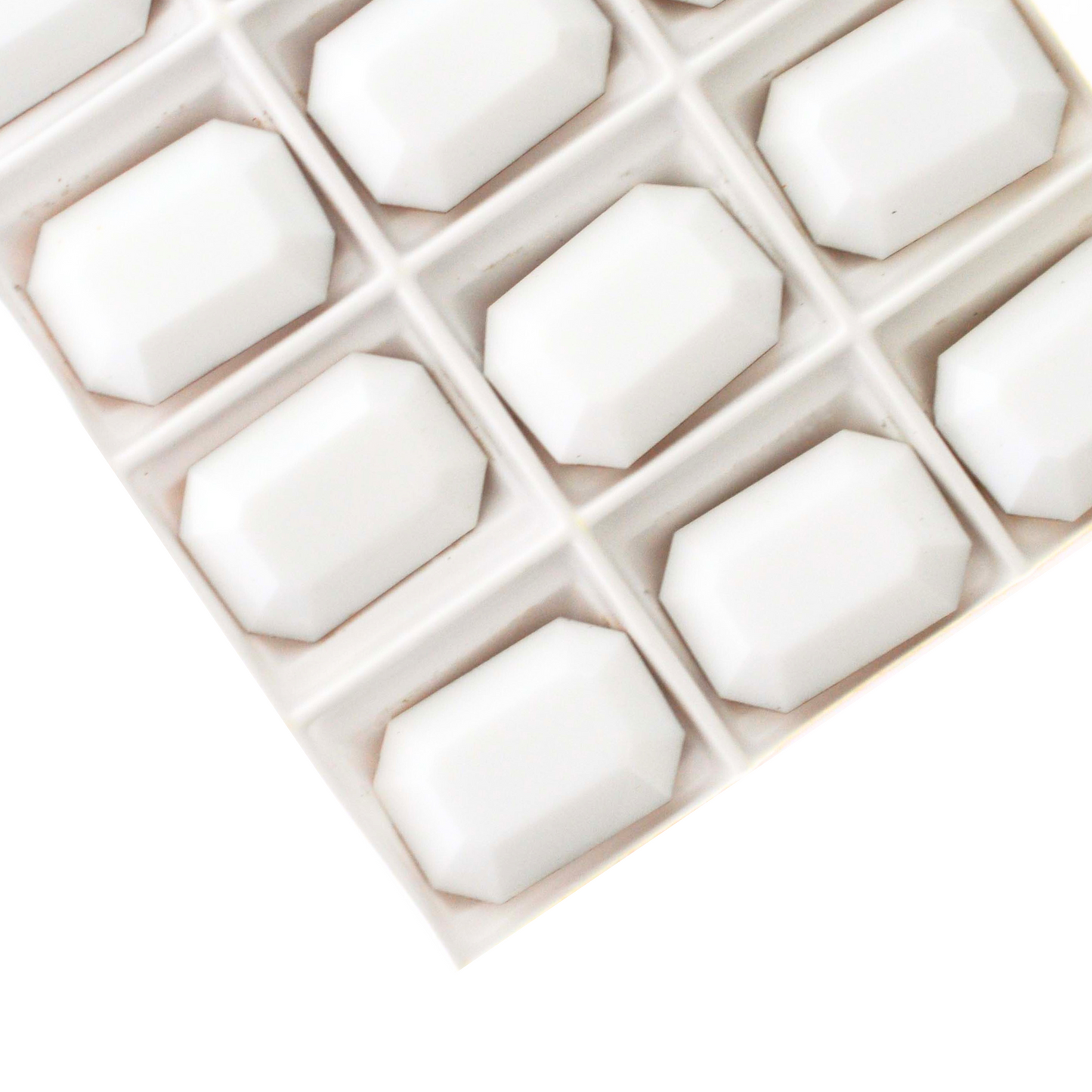 Octagon shaped faceted Austrian crystal rhinestones in the color Chalk White displayed on a white background.