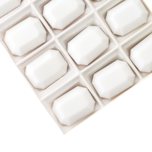 Octagon shaped faceted Austrian crystal rhinestones in the color Chalk White displayed on a white background.