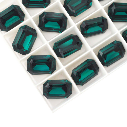 Octagon shaped faceted Austrian crystal rhinestones in the color Emerald displayed on a white background.
