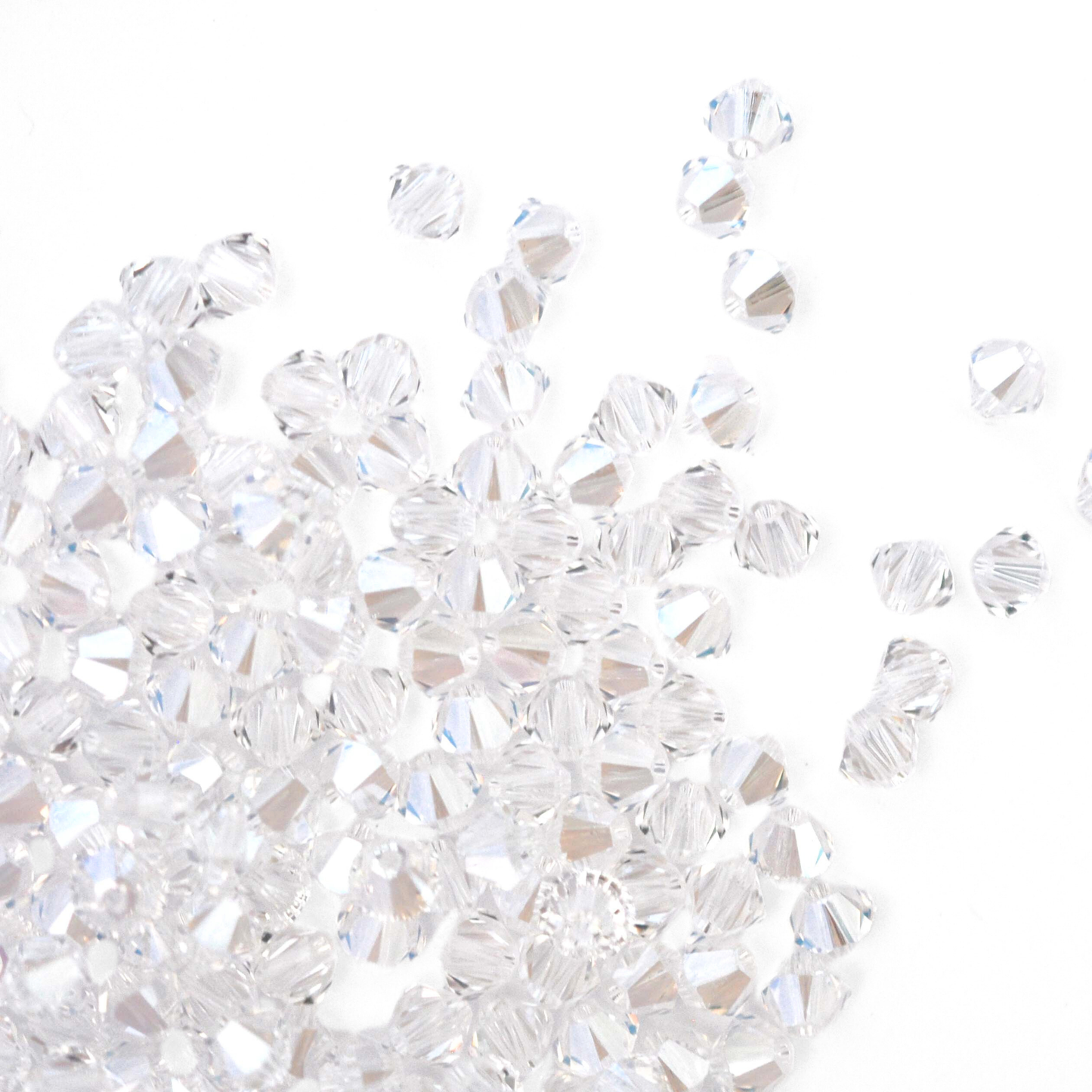 Austrian crystal 5328 bicone beads in the color Moonlight spilling out onto a white background.