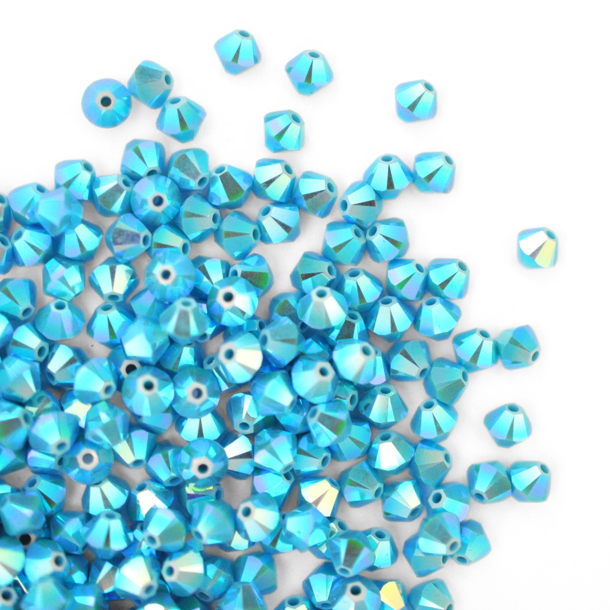 Austrian crystal 5328 bicone beads in the color Turquoise AB2X spilling out onto a white background.