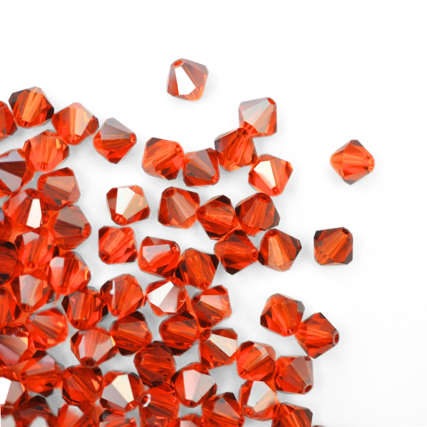 Austrian crystal 5328 bicone beads in the color Red Topaz Satin spilling out onto a white background.