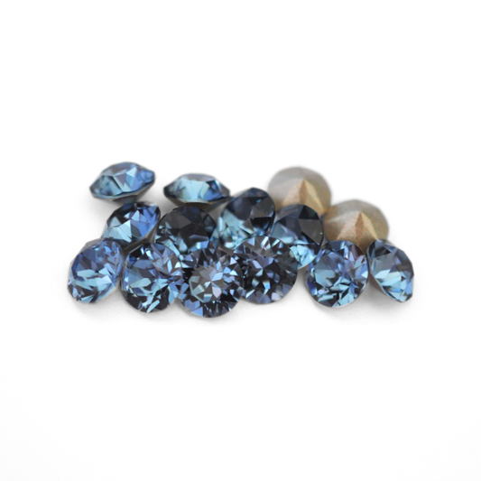 Round faceted Austrian crystal rhinestones in the color Denim Blue displayed on a white background