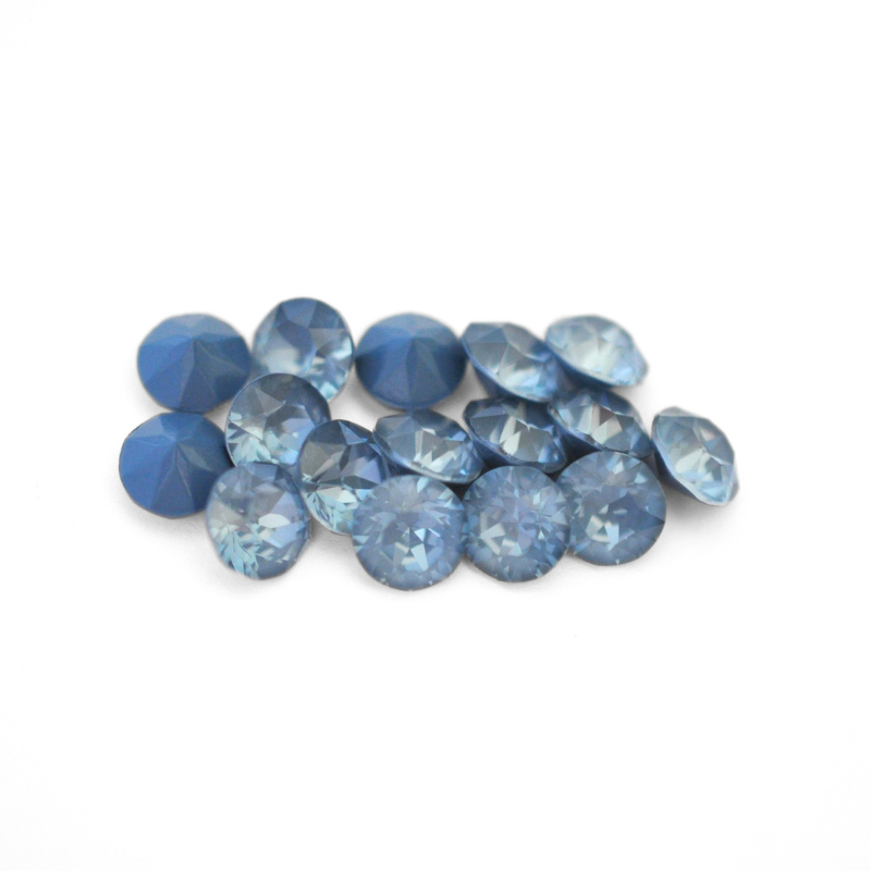 Round faceted Austrian crystal rhinestones in the color Denim Ignite displayed on a white background