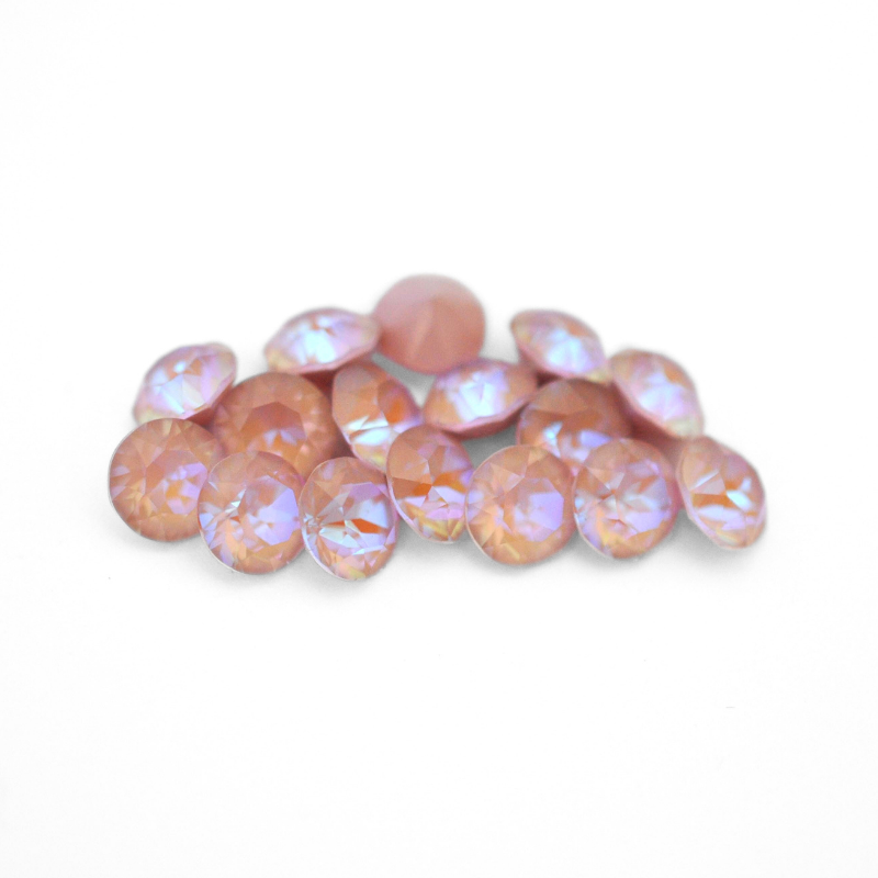 Round faceted Austrian crystal rhinestones in the color Dusty Pink Delite displayed on a white background