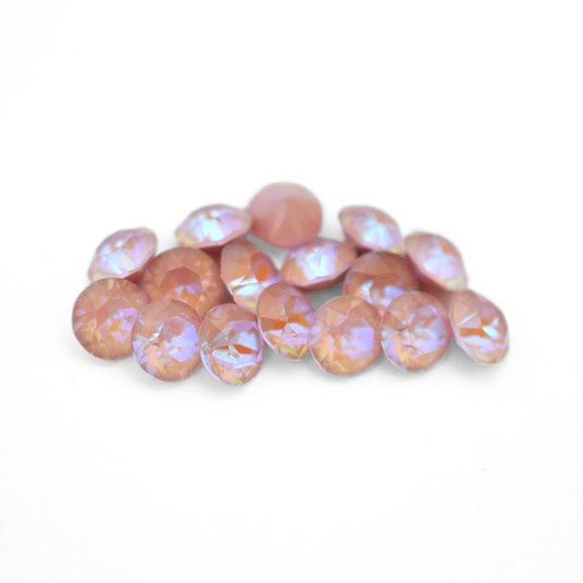 Round faceted Austrian crystal rhinestones in the color Dusty Pink Delite displayed on a white background
