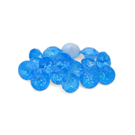 Round faceted Austrian crystal rhinestones in the color Electric Blue Ignite displayed on a white background